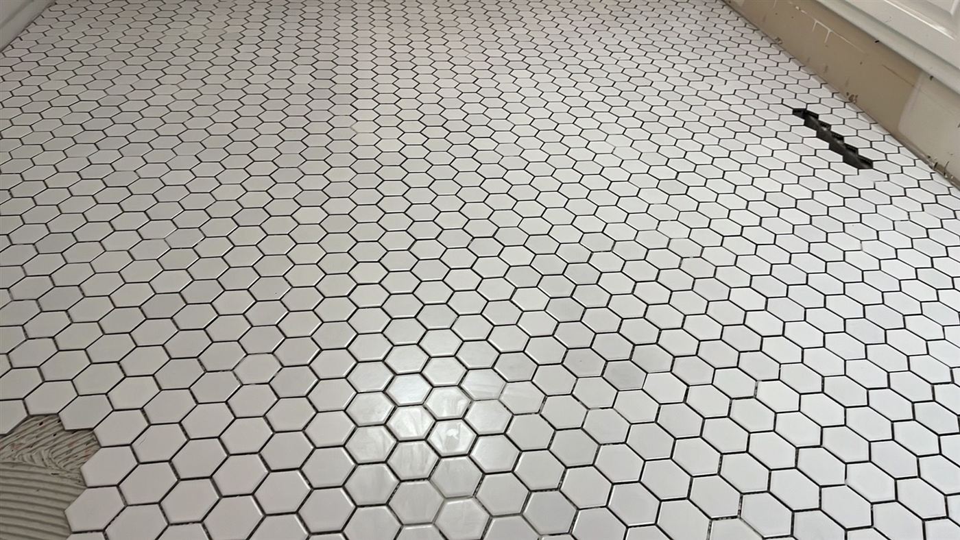 White hexagon tile floor with dark grout